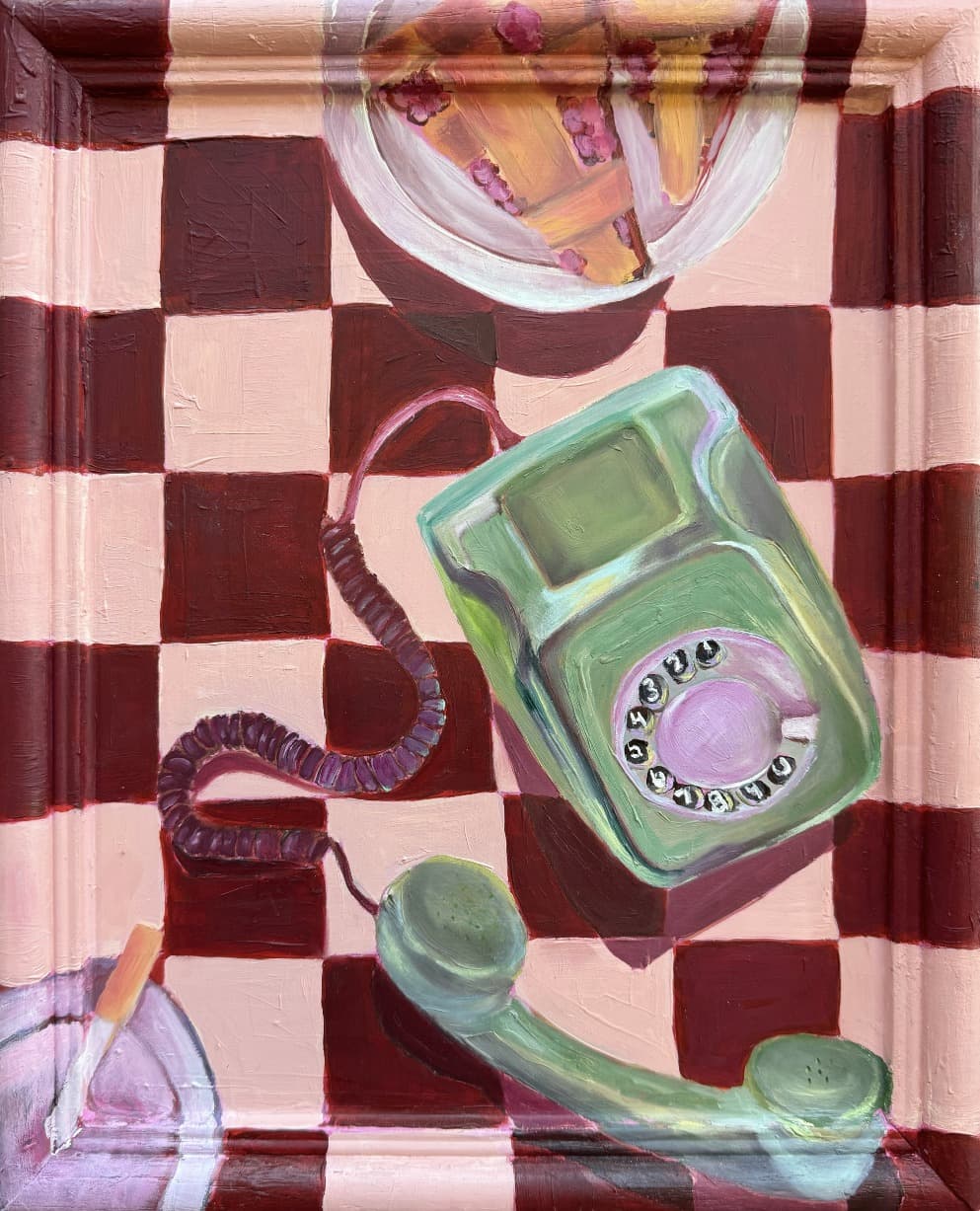 A mint green rotary phone with its receiver off the hook on a burgundy and pink checkerboard, beside a slice of cherry lattice pie and a cigarette resting in a glass ashtray.
